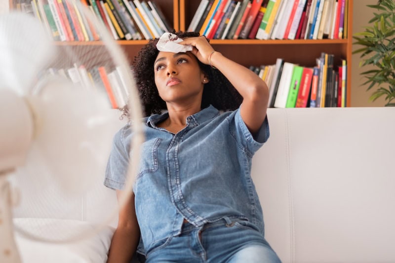 Common AC Problems and Solutions. Black woman sweating and trying to refresh at home.|How an Air Handler Works - Fan off the top of Air Conditioner Condenser during maintenance.