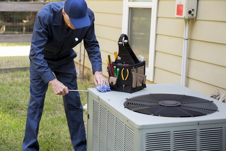 Senior Adult air conditioner Technician/Electrician services outdoor unit.