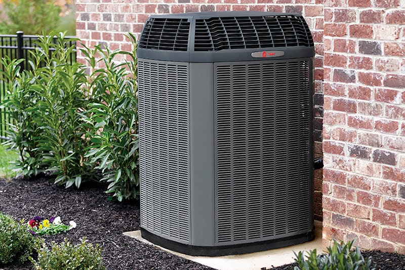 Spring is finally arriving in California! The days are getting longer, the flowers are blooming, and you’re probably already thinking about dusting off the patio furniture or tackling that messy garage. Photo of an HVAC unit installed outside of a brick home or building.