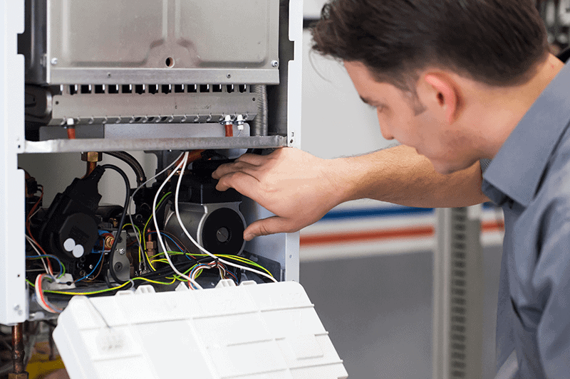 Image of somebody working on a heat pump. 4 Important Heat Pump Maintenance Tips.