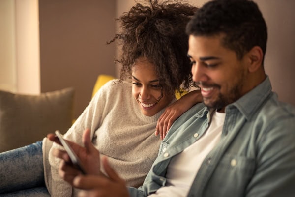 African american couple watching favorite TV show on a tablet.